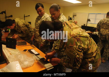 Sgt. Linda Pascal, seiner 661 militärische Polizeiaufgebot, Virgin Islands National Guard Spc überwacht. Karima Liburd als Sie Fingerabdrücke Pfc. Jahdisha Augustinus während der jährlichen Ausbildung des VING. Das jährliche Training war auf St. Croix, VI, Jan. 30, 2017 Feb 3, 2017 statt. (U.S. Army National Guard Foto von Armee Sgt. Priscilla Desormeaux/Freigegeben) (Foto 7/8 Gegenstand zu markieren) Stockfoto