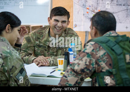 Eine Operations noncommissioned Officer vom 3. gepanzerte Brigade Combat Team, 1. Panzerdivision, unterhält sich mit einem Jordanien Streitkräfte - Arabische Armee Soldat während der Arbeit im Tactical Operations Center, oder TOC, für Übung eifrig Licht 2017, Jan. 30, 2017 bei der gemeinsamen Training Center in Jordanien. Eifrig, Licht ist eine jährliche Übung, dass die Züge sowohl in den USA als auch Jordanischen Truppen auf Bataillon und Brigade level Operationen während des simulierten Kampfszenarien und stellen gleichzeitig beide Kräfte die Gelegenheit, sich kennen zu lernen und die bilaterale Kommunikation verbessern. (U.S. Armee Foto von Sgt. Ein Stockfoto