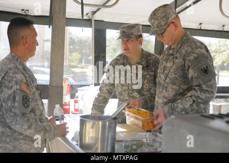 Armee finden Warrant Officer Candidate Joseph Parker, 143 Sustainment Command (auslandseinsätze) und CW2 Colby Bart, 11 Theater Luftfahrt Befehl, sowohl mit der Armee finden kulinarische Künste Team, die Speisen mit der 143 ESC Food Services Officer diskutieren, während der Vorbereitung einer Mahlzeit aus einer mobilen Küche Trailer am Orlando Streitkräfte finden. Parker, Bart, und die Armee finden kulinarische Künste Team wurden Proben für die kommende 42. jährlichen militärischen Culinary Arts Wettbewerb. Stockfoto