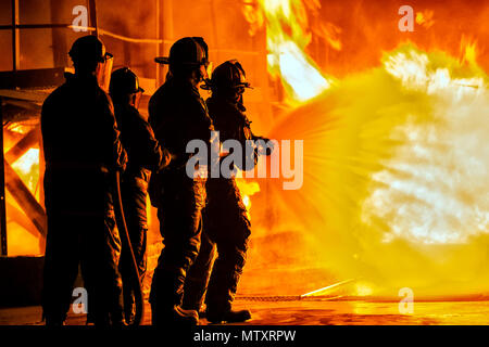 JOHANNESBURG, Südafrika - Mai, 2018 Feuerwehrmänner unten sprühen Feuer während der Brandbekämpfung Training Stockfoto