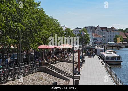 Cafés mit Touristen am Ufer der Trave in der Altstadt von Lübeck, Deutschland Stockfoto