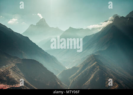 Das atemberaubende Panorama der mächtigen Misty schneebedeckten Himalaya und den Schluchten mit den Nadelwäldern. Nepal. Idealer Hintergrund für die verschiedenen Arten von Collagen und Illustrationen. Stockfoto