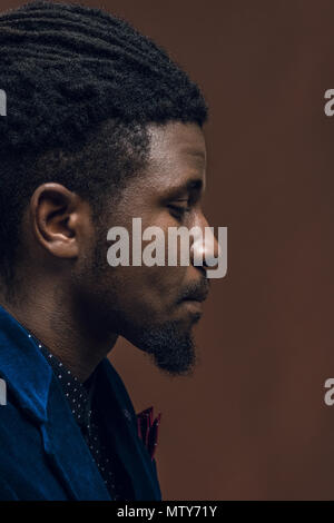 Seitenansicht des stattlichen afrikanische amerikanische Mann mit Dreadlocks isoliert auf Braun Stockfoto