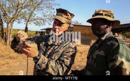 Cpl. Seth Carney, ein rifleman mit speziellen Zweck Marine Air-Ground Task Force - Krisenmanagement - Afrika, erklärt, wie man effektiv einen Kompass für die Navigation zu einem Mitglied des senegalesischen Compagnie Füsilier de Marin Commando während vier - Woche Woche Training an Toubakouta, Senegal, 25. April 2017. Marines mit SPMAGTF-CR-AF und der COFUMACO ein vierwöchiges Training, Advanced combat Brenntechniken, einem Maschinengewehr Reichweite und eine Live-fire Platoon Angriff Angebot durchgeführt. Stockfoto