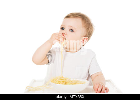 Little Boy in Hochstuhl essen Spaghetti von Hand auf weißem Hintergrund Stockfoto