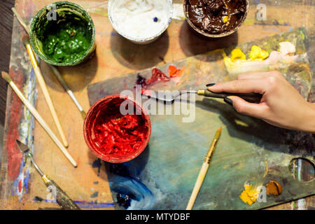 Zugeschnittenes Bild des Künstlers Lackierung auf Palette in der Werkstatt Stockfoto