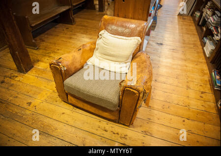 Zerschlagene Ledersessel in Richard Booth's Cinema Bookshop in Lion Street Hay-on-Wye Stockfoto