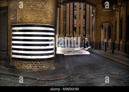 Markante horizontale Streifen als Warnung an die alten viktorianischen Bahnhof Torbogen in Southwark, London. Personen und moderne Gebäude im Hintergrund Stockfoto