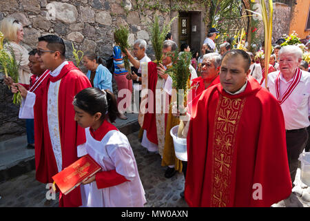 Katholische Priester sprengen Weihwasser auf die Gläubigen während der palmsonntag Prozession vom Parque Juarez zum Jardin - San Miguel de Allende, Mexiko Stockfoto