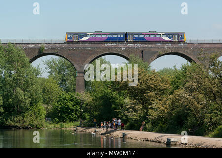 Eine nördliche Bahn pacer Zug fährt über ein Eisenbahnviadukt kreuzt Rötlich Vale Country Park in Manchester, Greater Manchester, UK Stockfoto