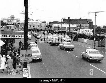 . Englisch: Konvoi. Auf der Suche nach Papanui Kreuzung Kreisverkehr mit Fahrzeugen, die auf der Parade mit mehreren (mindestens 5) Polizei Autos. ca. 1967. 1966 oder 1967. Stan McKay 466 Papanui 1966 Stockfoto