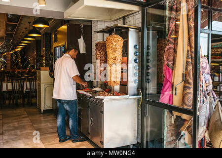 Editorial Bild der türkischen Koch ist Kochen und Schneiden gyros Portionen im Restaurant in Istanbul in der Türkei am 15. Juni 2017. Stockfoto