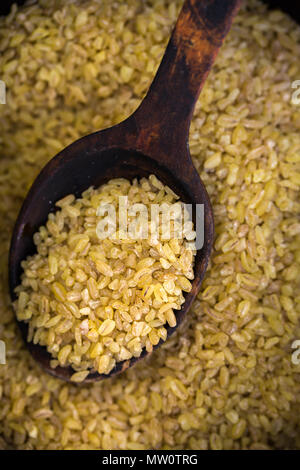 Bulgur in einem alten hölzernen Löffel Stockfoto