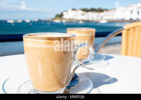 Nahaufnahme von zwei Gläser mit Caffe Latte macchiato auf einen Tisch auf der Terrasse eines Cafés an der Küste von Cadaques an der Costa Brava, Spanien Stockfoto