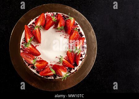 Käsekuchen mit Erdbeeren. Kuchen mit Erdbeeren dekoriert. Leckeren Käsekuchen mit frischen Erdbeeren dekoriert. Stockfoto