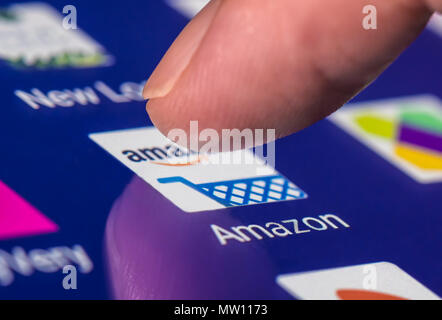 Finger, mit dem Amazon Symbol die App auf einem Tablet-PC oder Smartphone mit Touchscreen zu laden. Stockfoto
