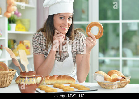 Schöne junge Frau in der Köche hat Backen Stockfoto