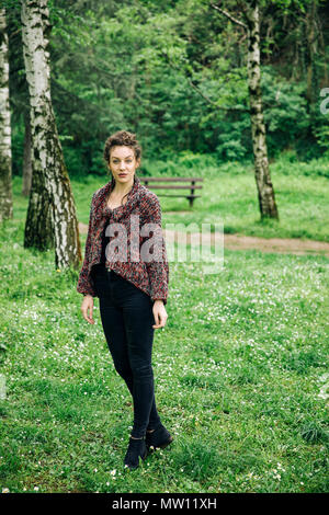 Junge Frau mit modernen Pullover und posiert im Park Stockfoto