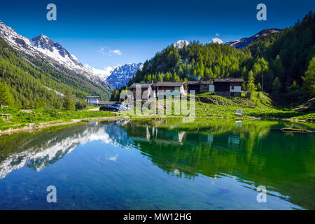 Spiegelungen der Berge und Häuser, Gouille, Arolla, Evolène, Schweiz, Stockfoto