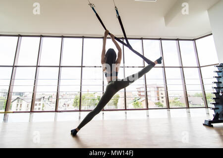 Yoga in einem weißen Turnhalle Fliegen. Gymnastik führt körperliche Übungen Stockfoto