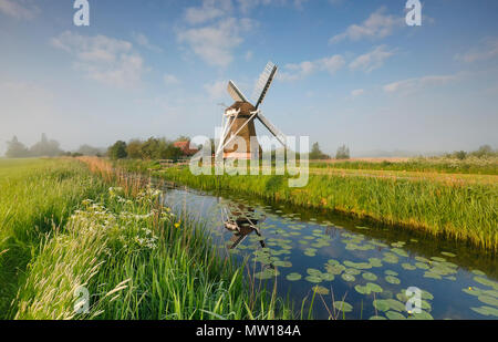 Charmante Mühle am Fluss über blauen Himmel am Morgen Stockfoto