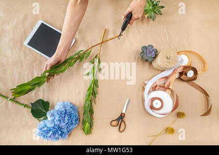 7/8 shot der weiblichen Florist mit gartenschere schneiden Stammzellen beim Anordnen von Pflanzen Stockfoto