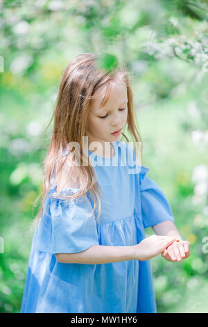 Entzückende kleine Mädchen in blühender Apfelgarten an schönen Frühlingstag Stockfoto