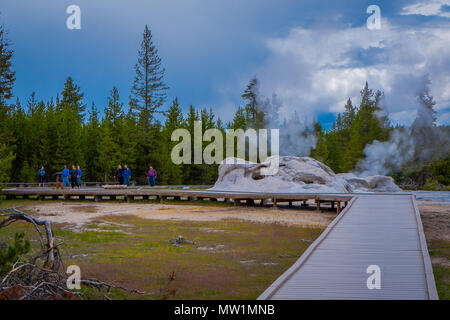 YELLOWSTONE, Montana, USA, 24. Mai 2018: Nicht identifizierte Personen laufen über eine hölzerne Struktur genießt die Aussicht von Giant Geysir, die zweithöchste Geysir der Welt in Yellowstone National Park Stockfoto