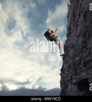 Man klettert eine hohe Gefahr Berg mit einem Seil Stockfoto