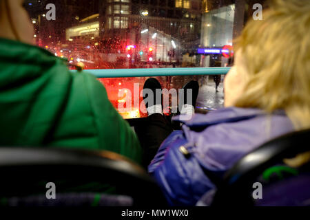 Frauen ihre Füße ruhen auf der Fensterbank des vorderen Fenster der double-decker Bus in London. Stockfoto