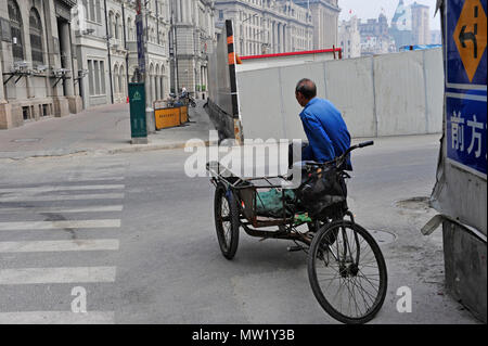 Candid Street Szene mit Mann auf einem Zyklus Rikscha, Shanghai, China warten Stockfoto