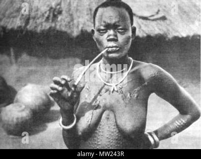 . Eine afrikanische Frau aus Shilluk Stamm Rauchen einer Pfeife (Foto in der Nähe von Malakal Stadt übernommen, South Sudan). Das Foto wahrscheinlich von Kazimierz Nowak (1897-1937) während seiner Reise durch Afrika - eine polnische Reisende, Korrespondent und Fotograf. Wahrscheinlich der erste Mensch an der Welt, die allein in Afrika von Norden nach Süden durchquert und von Süden nach Norden (von 1931 bis 1936; zu Fuß, mit dem Fahrrad und Kanu). . Ca. ca. 1931-36. Wahrscheinlich Kazimierz Nowak oder ein unbekanntes Thema 653 Frau rauchen Rohr Stockfoto
