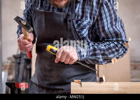 Close up erfahrener Tischler in Arbeitskleidung und kleine Steuerungsfunktionen für Eigentümer in Holzarbeiten Workshop, mit Meißel zum Schneiden von Holz in worksho Stockfoto