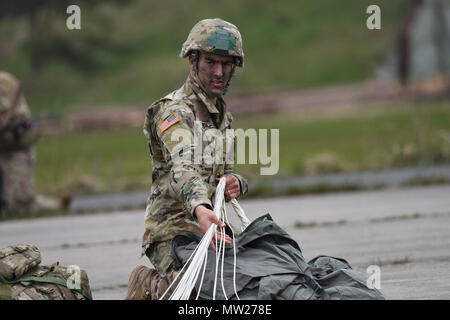 Ein Sky-Soldat aus C Company, 2. Bataillon, 503. Infanterieregiment 173rd Airborne Brigade versammelt seine Ausrüstung und verstaut seinen Fallschirm bei einem gemeinsamen Luft Betrieb und Flugplatz Anfall mit der Armee der Tschechischen Republik während des Trainings einen gemeinsamen Bereich als Teil der Übung Saber Junction 17 in Mimon, Tschechien 17. April 2017. Übung Saber Junction demonstriert die Fähigkeit der 173rd Airborne Brigade zu schnell bewegen und montieren ihre Kräfte in Zusammenarbeit mit NATO-Verbündeten, kritische Ressourcen, die es ermöglicht sichere folgende entscheidende Ausrüstung Land Luft zwingt. Stockfoto