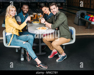 Gruppe von Freunden klirren Becher Bier bowling club vor der Gassen Stockfoto