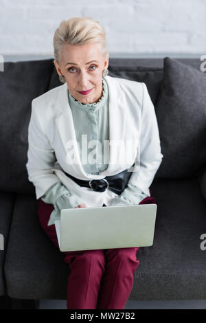 Ansicht von oben der schönen Senior Business Frau mit Laptop auf dem Sofa Stockfoto