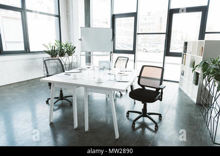 Moderne Einrichtung mit Schreibtisch, Papiere, Stühle und Whiteboard Stockfoto