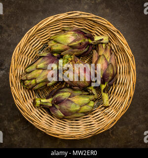 Artischocken in einem Weidenkorb. Stockfoto