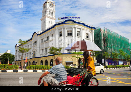 Ein Tourist in einer trishaw Ansichten der Wisma Kastam (malaiische Bahnhofsgebäude), Teil der Penang Heritage Area. Nie ein Bahnhof, sondern Zollstellen Stockfoto