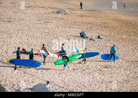 Mitglieder der Newquay Surf Life Saving Club ihre surfbretter auf Fistral Beach in Newquay Cornwall. Stockfoto