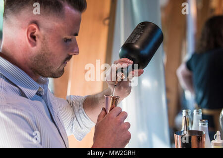 Ein Barkeeper bereiten einen Cocktail an einem Gin tasting Event. Stockfoto