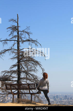 Frau auf einem Hügel mit Blick auf die Stadt, Ansicht von hinten Stockfoto