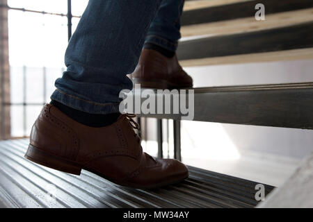 Nahaufnahme der männlichen braun Leder Schuhe moderne Schritte. Foto von einem Mann oben auf der Treppe im Innenbereich. Stockfoto