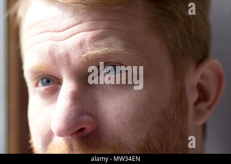 Junge mit tiefblauen Augen, blickte in Distanz. In der Nähe von schönen jungen Mann mit blauen Augen und Ingwer Haar Blick nach oben. Stockfoto