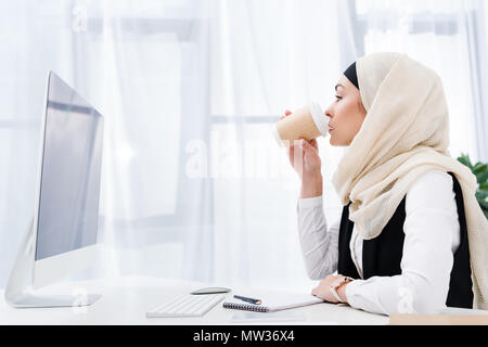 Seitenansicht des muslimischen Geschäftsfrau trinken Kaffee im Büro Stockfoto