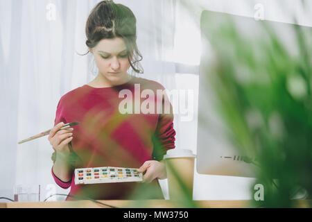 Junge Frau mit Aquarell Palette und Pinsel Stockfoto