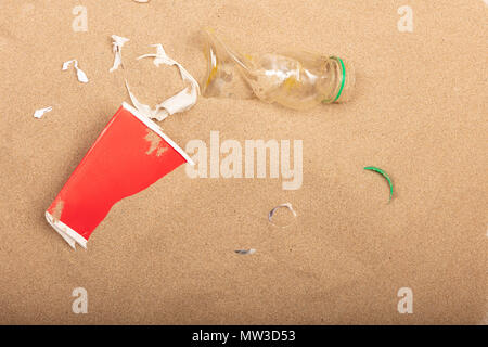 Abfallbehälter, Kunststoff Flaschen und andere Arten von Abfällen liegen auf dem Sand des Strandes Stockfoto