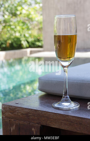 Glas Wein auf das Bett neben dem Pool. Stockfoto