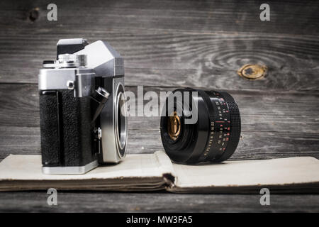 Eine alte Kamera mit einem Objektiv auf einer hölzernen Hintergrund, Platz für Text Stockfoto