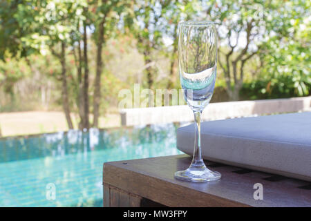 Glas Wein auf das Bett neben dem Pool. Stockfoto